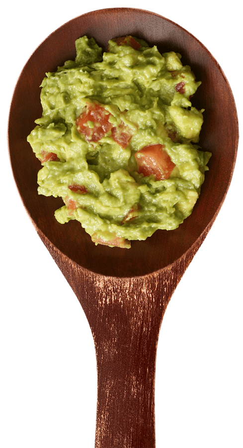Wooden spoon piled with fresh guacamole