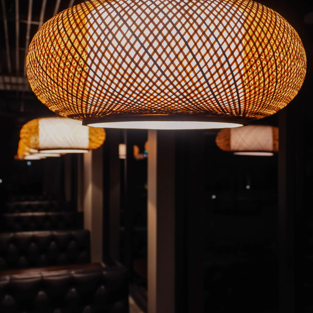 Woven bamboo pendant lights above the leather banquettes in the dining room