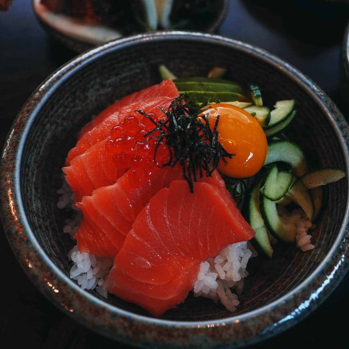 Tuna sashimi rice bowl with ikura, cucumber, avocado and egg yolk