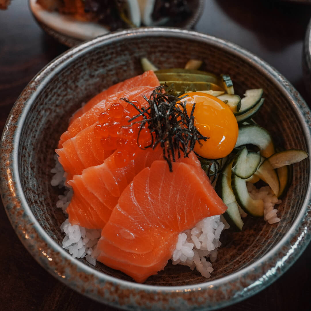 Salmon sashimi rice bowl with ikura, nori, cucumber and egg yolk