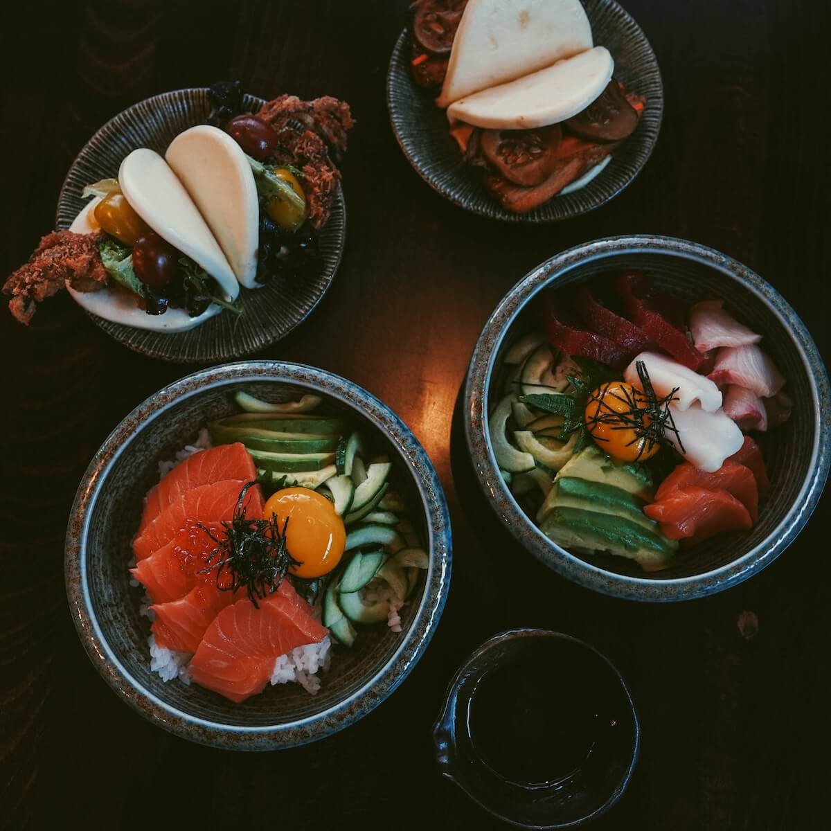 Spider bao and chashu bao served alongside sashimi rice bowls