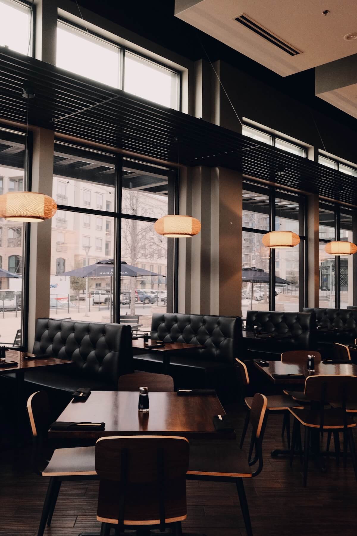 Leather banquettes and bamboo pendant lights along the dining room windows