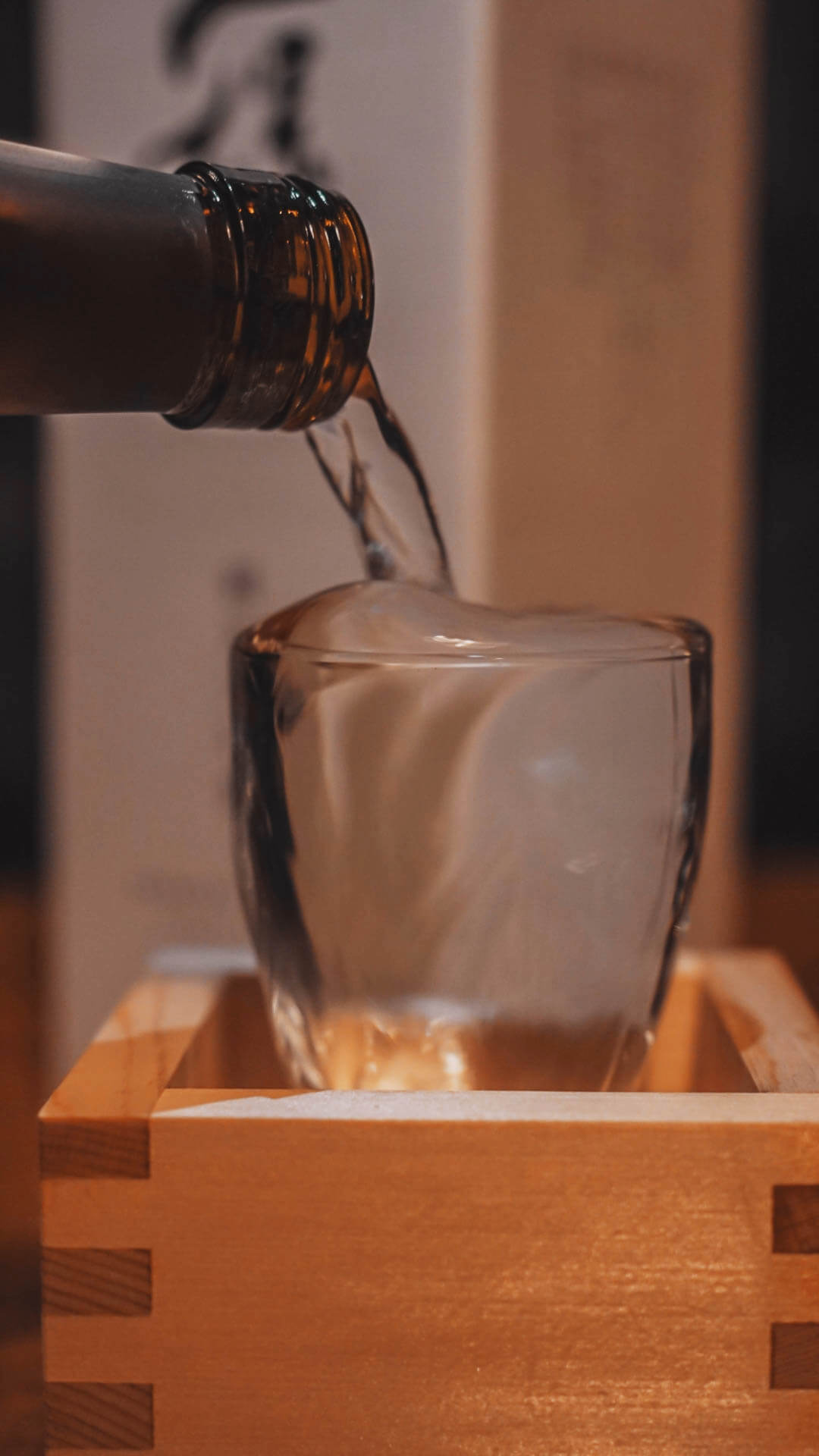 Sake poured to overflow into a wooden masu box