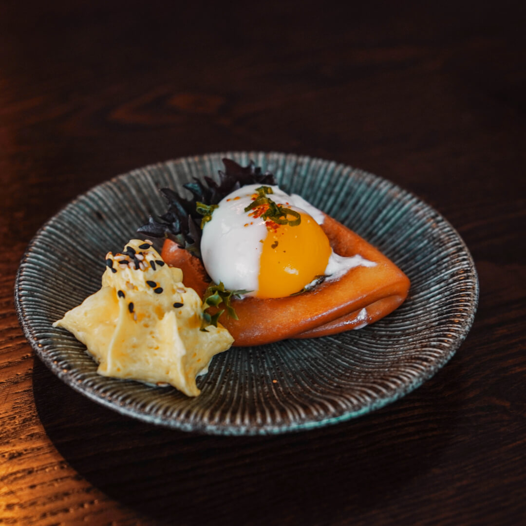 Slow-cooked egg over fried bread with whipped egg and micro greens