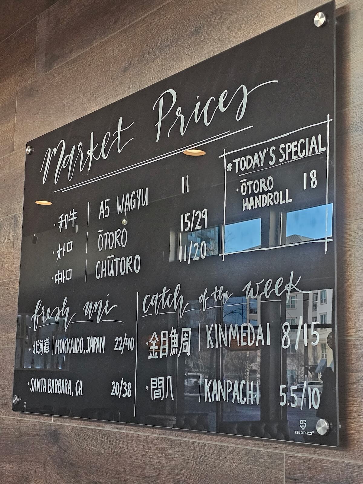 Market prices board at Musashi listing A5 wagyu, otoro, chutoro, Hokkaido uni, kinmedai and kanpachi
