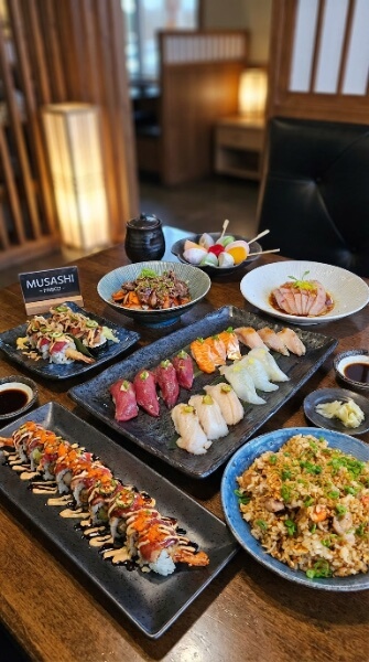 A full table of nigiri, specialty rolls, fried rice and mochi