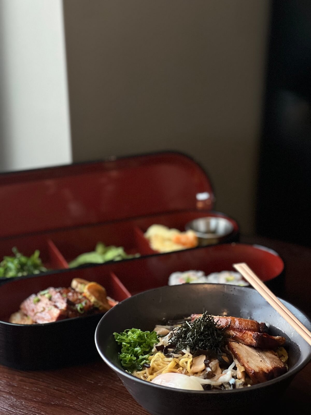 Tonkotsu ramen with chashu pork, served alongside a bento box