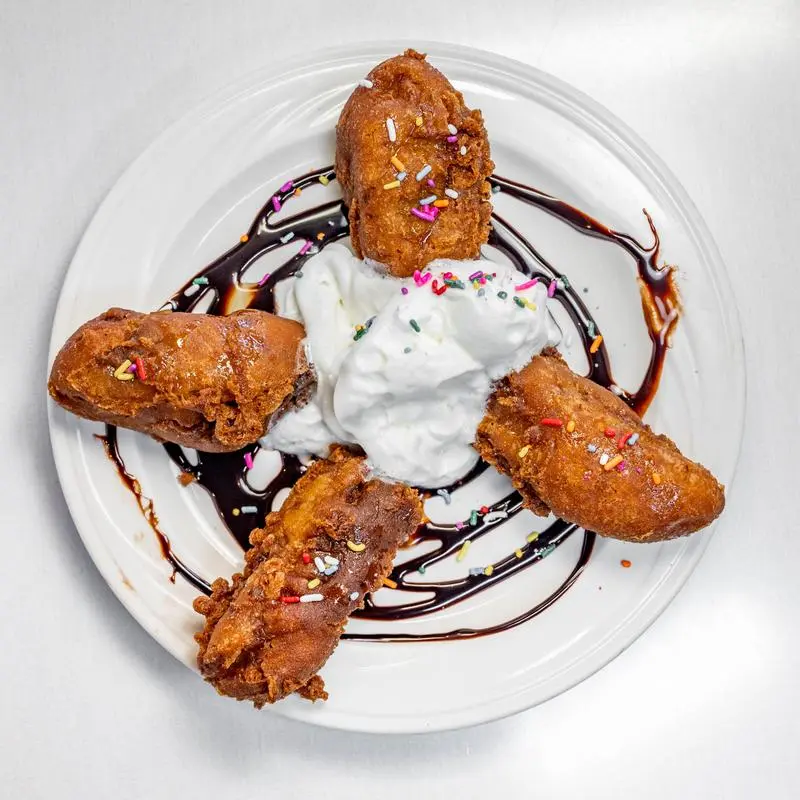 Fried banana with whipped cream and chocolate drizzle